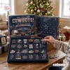 Close-up view of Dallas Cowboys Christmas Advent Calendar with person opening numbered compartments displaying collectible ornaments.