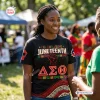 Front view of a woman wearing a black Delta Sigma Theta Black History Month Shirt with Juneteenth graphics.