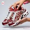 Hands holding a pair of red and white Delta Sigma Theta Elephant Air Max Plus Sneakers with floral and elephant graphics.