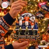Closeup of hands holding a Denver Broncos Peyton Manning Elway Nix Ornament in front of a lit Christmas tree.