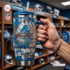 Hand holding Detroit Lions 96th Anniversary Tumbler with Handle featuring blue tie dye pattern.