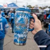 Hand holding a Detroit Lions 96th Anniversary Tumbler with Handle outdoors at a tailgate.
