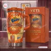 Front view of Fanta 86th Anniversary YETI Handle Tumbler with orange flame graphics and a matching gift box.