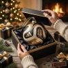 Closeup of hands opening a black gift box holding a FIFA World Cup 2026 Christmas ornament.