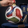 Hand holding a FIFA World Cup 2026 Trionda Ball Christmas Ornament with red, white, and blue host nation designs.