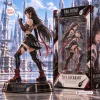 Side view of Final Fantasy Tifa Lockhart vinyl figure standing on a decorated circular base beside its packaging box.