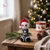 Front view of a funny Jack Skellington crochet Christmas ornament with black and white stripes and a red hat on a wooden table.