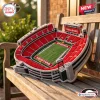Angled view of a Georgia Bulldogs Sanford Stadium plush pillow resting on a wooden bench outdoors.