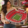 A smiling woman holding a detailed Georgia Bulldogs Sanford Stadium plush pillow.