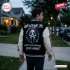 Back view of a person wearing a Ghostface Woodsboro Scary Movie Varsity Jacket outdoors at dusk.