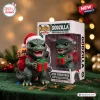 Front view of Godzilla 2026 Christmas vinyl figure holding a red and green gift box with Santa hat and box.