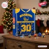 Front view of a blue and yellow Golden State Warriors Steph Curry advent calendar on a table with mini keychains.