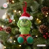 Hanging crochet Grinch Christmas ornament on a decorated pine tree branch.
