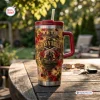 Front view of a Guns N Roses tumbler with a red handle and straw sitting on a wooden table.