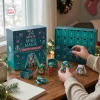 Closeup of hands opening a teal Hatsune Miku Magical Advent Calendar with numbered drawers and miniature figures.