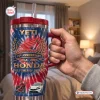 Hand holding red handle tumbler with Honda 78th Anniversary 1948-2026 design.