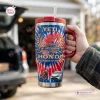 Hand holding a Honda 78th Anniversary 1948-2026 Handle Tumbler with tie-dye pattern and car graphics.