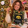 Woman holding Iowa Hawkeyes 2026 Christmas Advent Calendar near a decorated tree.