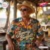 Man wearing a Jimmy Buffett Island Life Hawaiian shirt with tropical sunset print and palm tree graphics at an outdoor table.