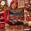 Smiling woman holding a Kansas City Chiefs Kingdom Christmas Advent Calendar in a festive living room setting.