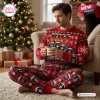 Man holding a mug while wearing a red Christmas sweater and patterned jogger pants.