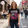 Front view of woman wearing a black Las Vegas Raiders Breast Cancer Awareness shirt on a city street.