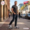 Man wearing Las Vegas Raiders Custom Sport Air Max Plus Shoes while walking on a city sidewalk.