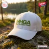 Front view of the Make Halo Great Again White Baseball Cap resting on a mossy rock outdoors.