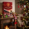 Front view of Manchester United Red Devils Old Trafford 2026 Advent Calendar on a mantelpiece with football ornaments.