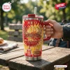 Hand holding a McDonald's 86th Anniversary YETI Handle Tumbler on an outdoor wooden picnic table.