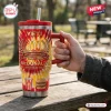 Hand holding a McDonald's 86th Anniversary YETI Handle Tumbler on a wooden table outdoors.