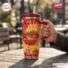 Hand holding McDonald's 86th Anniversary YETI Handle Tumbler on outdoor wooden table.