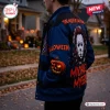 Side angle view of a person wearing a Michael Myers Horror Blue Varsity Jacket with graphic prints outdoors.
