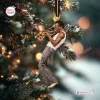 Hanging ornament of a trumpet player wearing a white tank top on a decorated tree.