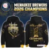 Front and back view of a Milwaukee Brewers 2026 World Series Champions black hoodie with gold graphics.