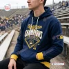 Front view of a fan wearing a blue Milwaukee Brewers 2026 World Series Champions hoodie in a stadium.
