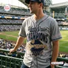 Man wearing Milwaukee Brewers 2026 World Series Champions Grey Baseball Jersey at stadium.