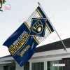Outdoor view of a Milwaukee Brewers 2026 World Series Champions house flag hanging from a flagpole against a white house.