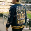 Rear view of the Milwaukee Brewers 2026 World Series Champions navy varsity jacket at a baseball stadium.