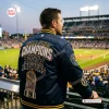 Back view of a person wearing the Milwaukee Brewers 2026 World Series Championship Baseball Jacket at a stadium.