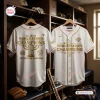 Front and back view of the Milwaukee Brewers 2026 World Series Gold Baseball Jersey hanging in a locker room.