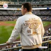 Rear view of a man wearing a white Milwaukee Brewers Champions White Baseball Jacket 2026 at a stadium.