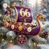 Front view of a purple and gold Viking ship Christmas ornament hanging on a pine tree.