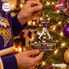 Hands hanging a Minnesota Vikings Stefon Diggs Miracle Touchdown ornament on a lit Christmas tree.