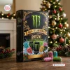 Front view of Monster Energy All Flavors Advent Calendar 2026 box with ornate gold borders next to a decorated Christmas tree.
