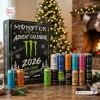 Front view of Monster Energy Drink Advent Calendar 2026 with twenty four cans displayed against a holiday fireplace background.