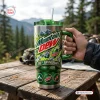 Hand holding a Mountain Dew 86th Anniversary stainless steel tumbler with a handle outdoors against a mountain backdrop.