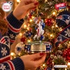 Close-up of hands hanging a New England Patriots Efton Chism III Christmas ornament on a tree.