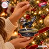 Close-up of a football player Christmas ornament hanging on a lit tree.