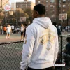 Rear view of a man wearing a white New York Knicks 2026 NBA Champions Hoodie at an outdoor basketball court.